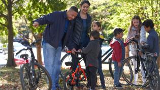 Adults and children preparing for a bike ride